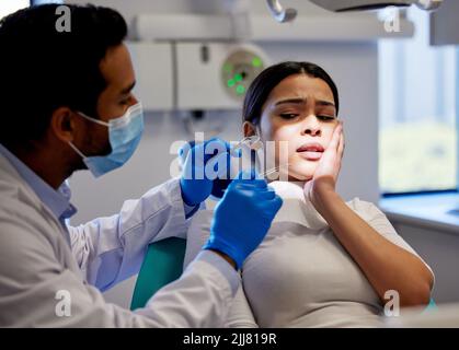 Lassen Sie Ihre Zahnschmerzen ein Ding der Vergangenheit. Eine junge Frau, die Schmerzen und Angst, während eine zahnärztliche Prozedur an ihr durchgeführt. Stockfoto