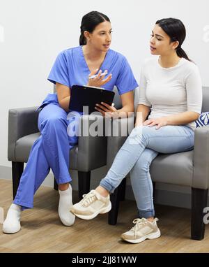 Eine Konsultation ist der Schlüssel. Ein Zahnarzt und ein Patient sprechen in einem Büro. Stockfoto