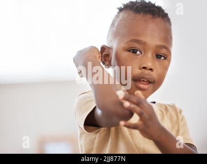 Boo Buhs passieren, Bandhilfen helfen. Ein entzückender kleiner Junge, der ein Bandaid auf seinen Arm trägt. Stockfoto