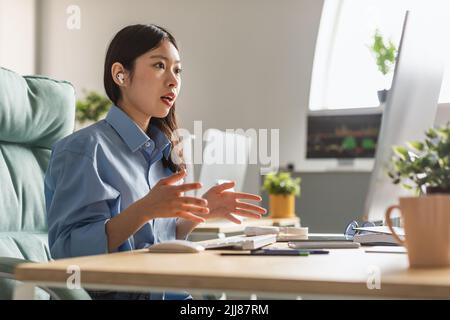 Asiatische Geschäftsfrau Video Anrufe Auf Computer Tragen Von Ohrstöpseln Im Büro Stockfoto