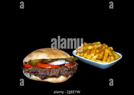 Döner Rindersandwich oder Sandviç Döner mit pommes frites isoliert auf schwarzem Hintergrund Stockfoto