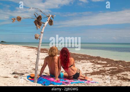 Blick auf das Strandpaar von hinten Sonnenbräune zusammen am tropischen feinen Sand von Sandspur Beach, Bahia Honda Key, Florida Keys Stockfoto