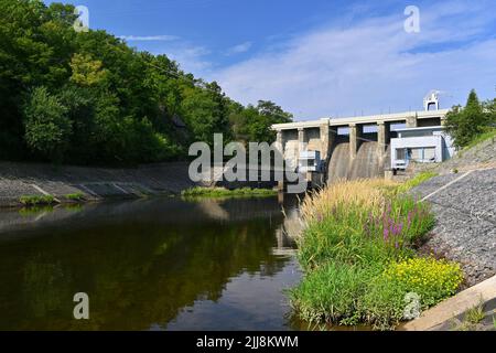 Ein Damm auf dem Brünner Stausee am Fluss Svratka mit einem kleinen Kraftwerk. Schöner sonniger Sommertag in der Natur. Stockfoto