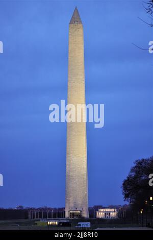 Blick auf das historische Denkmal für Washington und amerikanische Flaggen zu Ehren des ersten Präsidenten Amerikas unter dem blauen Abendhimmel, DC. USA Stockfoto