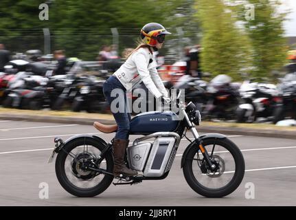 Hinckley, Leicestershire, Großbritannien. 24.. Juli 2022. Eine Frau fährt auf einem Elektromotorrad von Maeving während eines Weltrekordversuchs für das größte Motorradtreffen der Frauen am globalen Hauptsitz von Triumph Motorcycles. Credit Darren Staples/Alamy Live News. Stockfoto