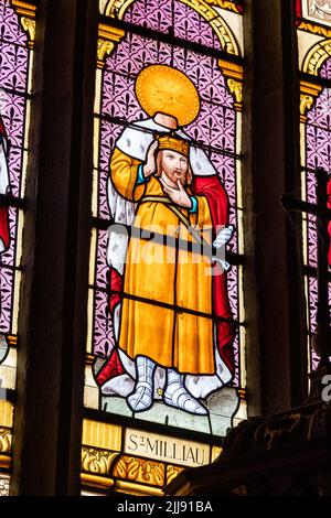 Ploumilliau (Plouilio), Frankreich. Buntglasfenster, in dem der heilige Milliau von Cornwall seinen enthaupteten oder enthaupteten Kopf in der Kirche hält Stockfoto