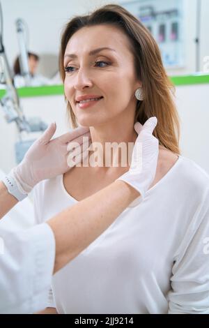 Dermatologe untersucht die Haut des Gesichts des Patienten Stockfoto