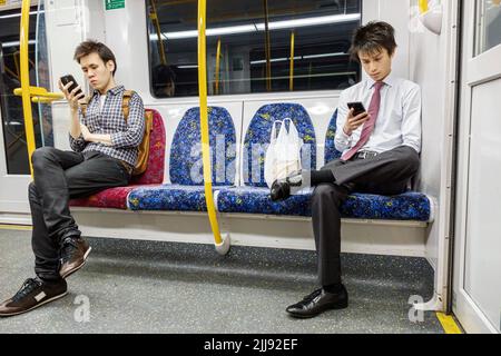 Sydney Australien, City Circle Eisenbahn Zug an Bord Fahrer Passagiere Fahrer asiatischen Mann Männer Blick auf Smartphone lesen SMS Pendler Stockfoto