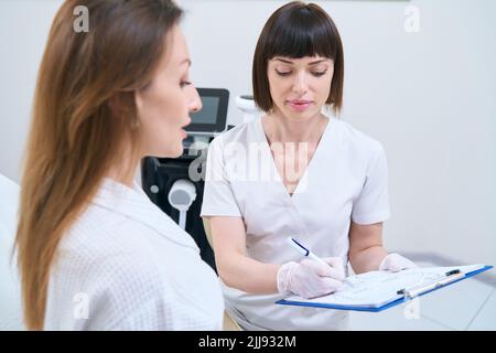 Die Frau wird in einem medizinischen und kosmetologischen Zentrum untersucht Stockfoto