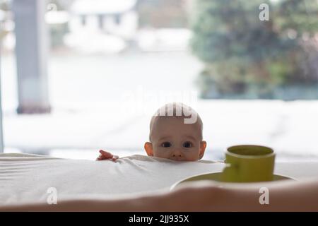 Neugieriges Kind Kleinkind will Unfug zu tun und beobachtet bis zu Eltern Bett zu heißen Kaffeetasse, Heimszene kopieren Raum Hintergrund Stockfoto