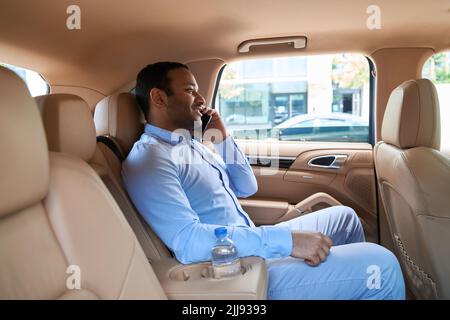 Passagier, der im Auto ein Gespräch über das Mobiltelefon führt Stockfoto