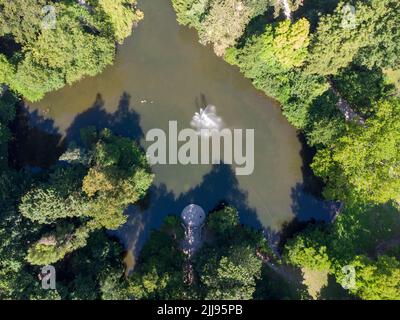 Eine Luftaufnahme eines floralen Wasserspritzern eines Brunnens auf einem Fluss Stockfoto