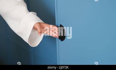 Frau Hand öffnet blauen Schrank Tür Panel oder moderne Schranktür Stockfoto