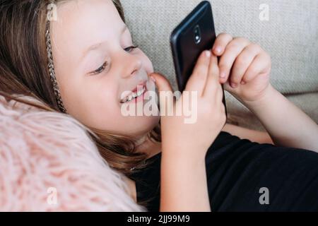 Kind Freizeit Unterhaltung Lächeln Mädchen spielen Telefon Stockfoto