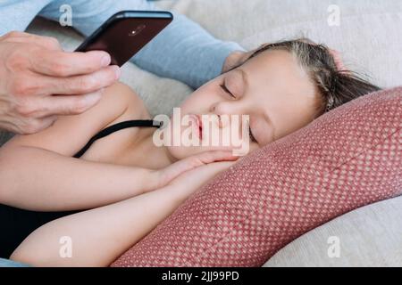Elternmomente schlafen Tochter Handy Foto Stockfoto