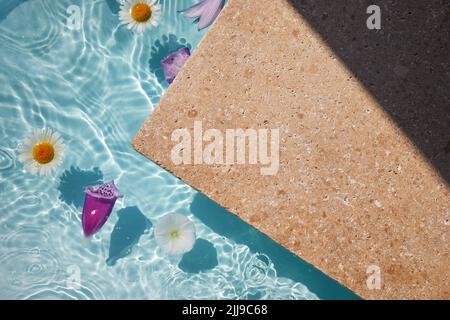 Produktförderung Beauty Kosmetik Schaufenster. Travertin Stein Display mit Blumen im Wasser. Stockfoto