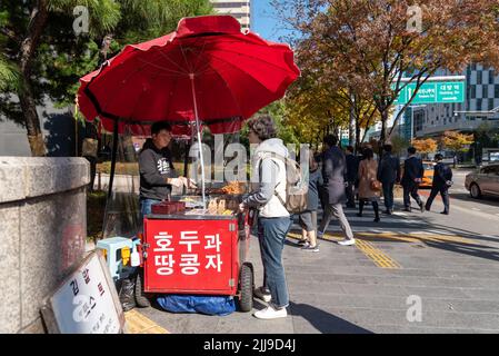 Seoul, Südkorea - 04. November 2019: Frau, die Lebensmittel am Lebensmittelstand auf der Straße im Yeouido-Viertel kauft. Es ist die wichtigste Finanzierung und Investition in Seoul Stockfoto