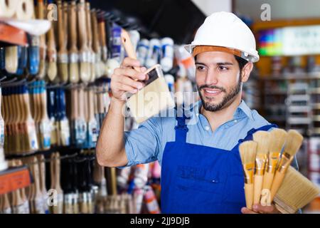 Vorarbeiter in blauen Overalls Wahl Bürsten Stockfoto