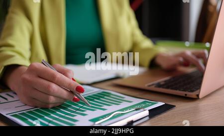 Buchhalterin, die mit statistischen Daten arbeitet und auf einem modernen Laptop tippt Stockfoto