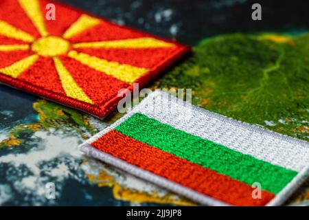 Die Flaggen Bulgariens und Nordmazedoniens stehen direkt vor einander, das Konzept der komplizierten Beziehungen zwischen den beiden Ländern Stockfoto