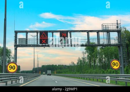 Straße mit leuchtenden Bezeichnung Banner-Schild auf der Straße Straßenreparatur und Geschwindigkeitsbegrenzung 90 und 70 km pro Stunde Stockfoto