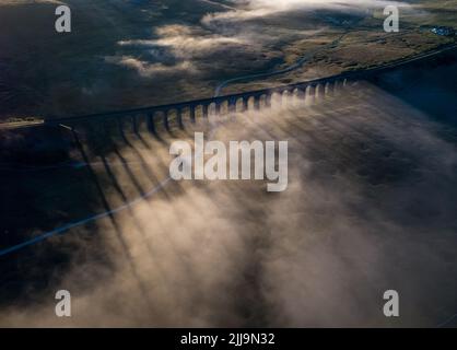 Drohnenansicht des legendären Ribblehead Viadukts, das am frühen Morgen im Nebel gehüllt wurde Stockfoto