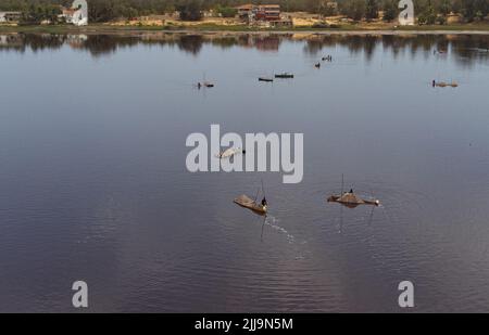 Ein Bild, das einige Salzgewinnungsarbeiter in ihren kleinen Booten in Pink Lake, Senegal zeigt. Stockfoto