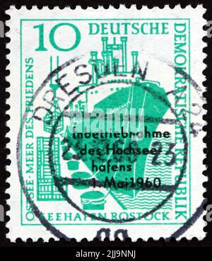 DEUTSCHLAND - UM 1960: Eine in Deutschland gedruckte Marke, die der Einweihung des Seehafens Rostock gewidmet ist, zeigt Schiff am Pier, um 1960 Stockfoto
