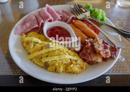 Blick von oben auf das Frühstücksset, Omelette, Wurst, Schinken und Speck. Stockfoto