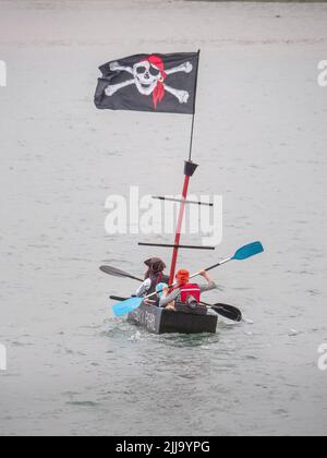 BIDEFORD, DEVON, ENGLAND - JULI 24 2022: Teilnehmer am jährlichen Water Festival Cardboard Boat Race, River Torridge. Regentag. Stockfoto