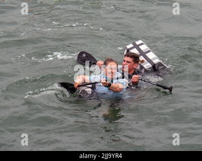 BIDEFORD, DEVON, ENGLAND - JULI 24 2022: Teilnehmer am jährlichen Water Festival Cardboard Boat Race, River Torridge. Regentag. Stockfoto