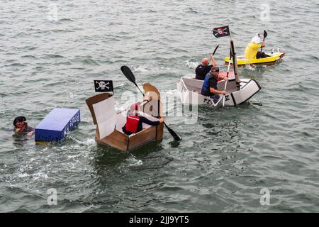 BIDEFORD, DEVON, ENGLAND - JULI 24 2022: Teilnehmer am jährlichen Water Festival Cardboard Boat Race, River Torridge. Regentag. Stockfoto