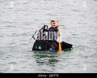 BIDEFORD, DEVON, ENGLAND - 24 2022. JULI: Teilnehmer am jährlichen Water Festival Cardboard Boat Race, River Torridge. Regentag. Stockfoto