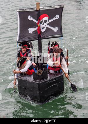 BIDEFORD, DEVON, ENGLAND - JULI 24 2022: Teilnehmer am jährlichen Water Festival Cardboard Boat Race, River Torridge. Regentag. Stockfoto