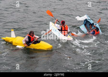 BIDEFORD, DEVON, ENGLAND - JULI 24 2022: Teilnehmer am jährlichen Water Festival Cardboard Boat Race, River Torridge. Regentag. Stockfoto