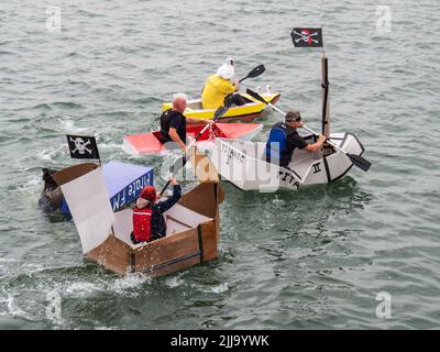 BIDEFORD, DEVON, ENGLAND - JULI 24 2022: Teilnehmer am jährlichen Water Festival Cardboard Boat Race, River Torridge. Regentag. Stockfoto