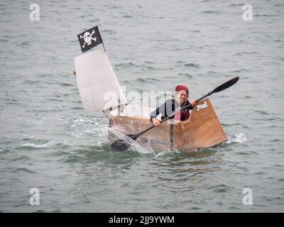 BIDEFORD, DEVON, ENGLAND - 24 2022. JULI: Teilnehmer am jährlichen Water Festival Cardboard Boat Race, River Torridge. Regentag. Stockfoto