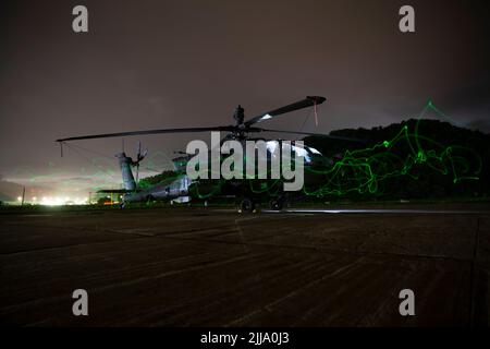 Ein AH-64E Apache-Hubschrauber, der dem Angriffsbataillon 4-2, 2. Combat Aviation Brigade, 2. Infantry Division, angehört, wird während der kombinierten Einheiten der Qualifikation für Luftwaffen am 21. Juli 2022, Rodriguez Live Fire Complex, Republik Korea, auf dem Flugfeld ausgetragen. Dies ist ein Foto mit langer Belichtung. (USA Armeefoto von Sgt. Oscar Toscano) Stockfoto