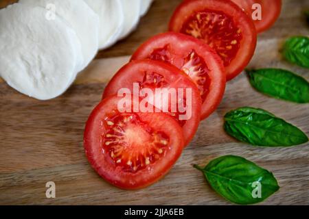 Tomaten auf der Rebe - Solanum lycopersicum - Basilikum-Mozzarella-Salat mit roten Tomaten - Mozarella - vegetarische Lebensweise und Kochkost - reife Tomaten Stockfoto