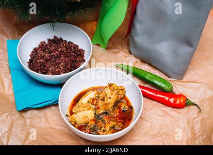 Zwei Portionen georgischer Gerichte. Eine tiefe Platte von Chakhohbili - ein traditionelles georgisches Gericht aus Huhn mit Kräutern. Eine tiefe Platte aus lobio - ein Gericht aus re Stockfoto