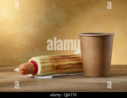 Hot Dog und Pappkaffee auf gelbem Hintergrund Stockfoto