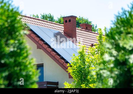 Hausdach mit Photovoltaikmodulen. Historisches Bauernhaus mit modernen Sonnenkollektoren auf Dach und Wand Hochwertiges Foto Stockfoto