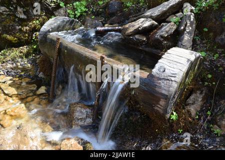 Typisch alpenländischen Holz- Brunnen mit frischem Wasser in Trinkwasserqualität im Freien Stockfoto