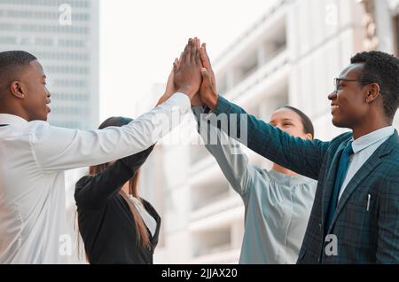 High Five for a Job Gut gemacht. eine Gruppe von Geschäftsleuten, die sich gegenseitig eine High Five in der Stadt geben. Stockfoto