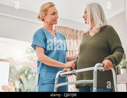 Eine Krankenschwester hilft ihrem Patienten mit einem Gehrahmen beim Gehen. Stockfoto