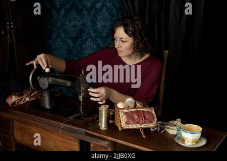 Eine Näherin aus dem Jahr 1920s, die an ihrer Nähmaschine arbeitet Stockfoto