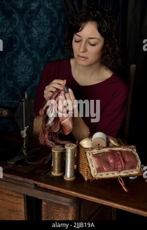 Eine Näherin aus dem Jahr 1920s, die an ihrer Nähmaschine arbeitet Stockfoto