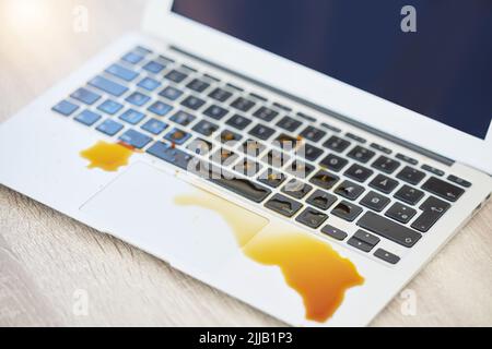 Jemand ruft die Werkstatt an. Ein Laptop mit verschüttetem Kaffee. Stockfoto