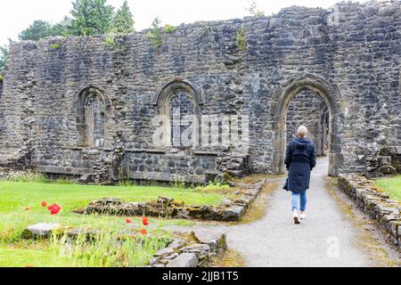 Whalley Abbey Ruins and Grounds, Model freigelassene Besucherin in ihren 50er Jahren besucht die Ruinen, Lancashire, England, Großbritannien, Sommer 2022 Stockfoto