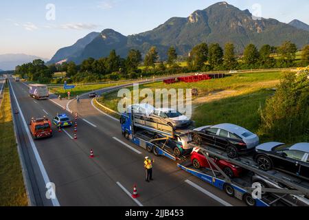 Brannenburg, Deutschland. 25.. Juli 2022. An der Ausfahrt 58 auf der Autobahn A93 in Richtung Tirol trennen Polizeibeamte in den frühen Morgenstunden Lastwagen und Autos. Ab 25.07.2022 tritt das Verbot des Lkw-Transitverkehrs im Inntal in Kraft. Kredit: Peter Kneffel/dpa/Alamy Live Nachrichten Stockfoto